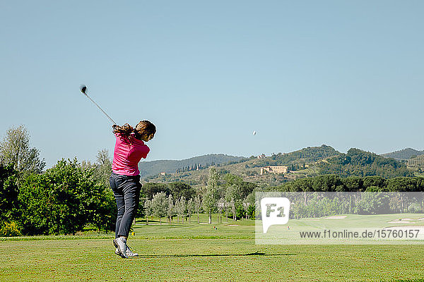Woman playing golf on golf course