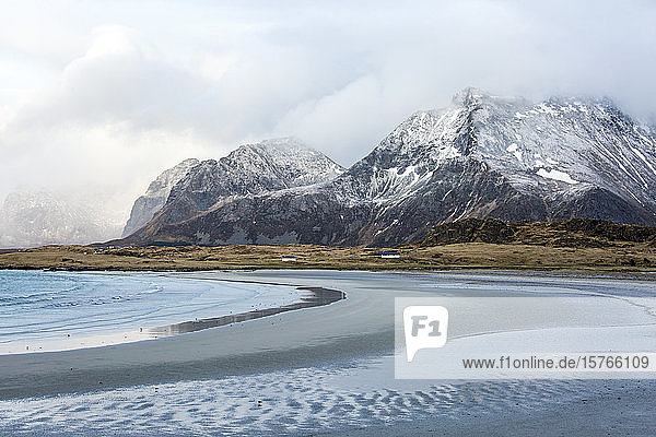 Mountains and remote ocean beach Ytresand Lofoten Norway