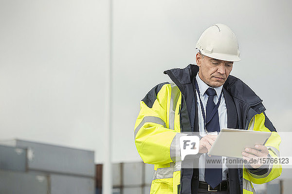Dock manager using digital tablet at shipyard