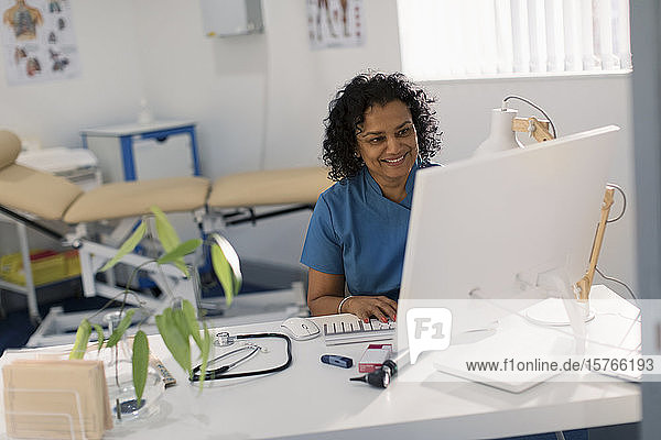 Female doctor working at computer in doctors office
