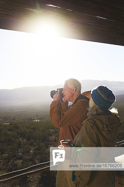 Älteres Paar mit Kamera auf sonnigem Safaribalkon