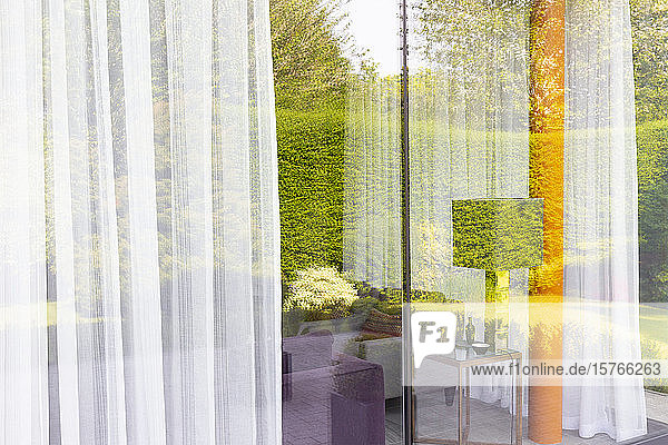 Spiegelung des Gartens in modernen  raumhohen Wohnzimmerfenstern