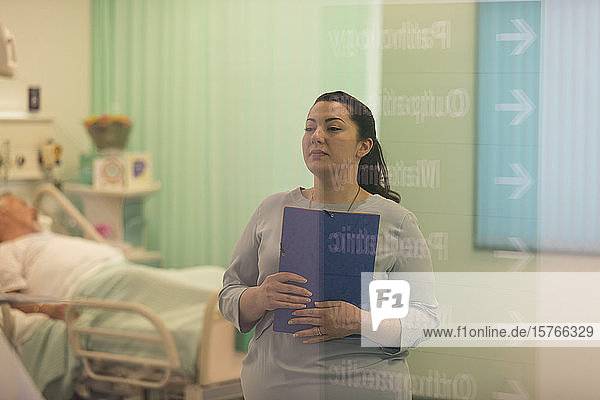 Ärztin mit Krankenblatt bei der Visite in einer Krankenstation