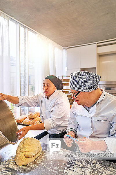 Koch und Student mit Down-Syndrom backen Brot in der Küche