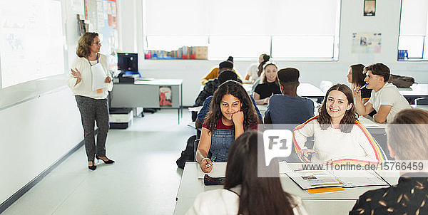 Highschool-Schülerinnen unterhalten sich während des Unterrichts am Tisch im Klassenzimmer