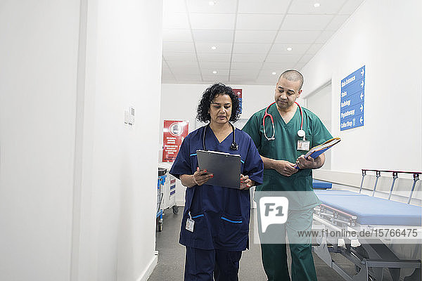 Ärzte mit Krankenblatt bei der Visite im Krankenhauskorridor