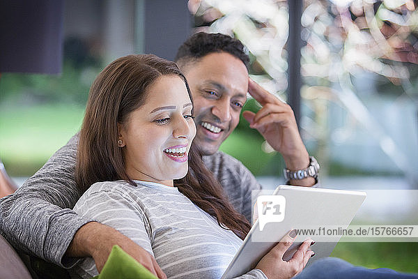 Glückliches Paar  das sich entspannt und ein digitales Tablet benutzt