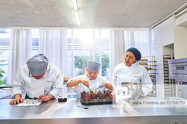 Koch und Schüler mit Down-Syndrom backen Muffins in der Küche