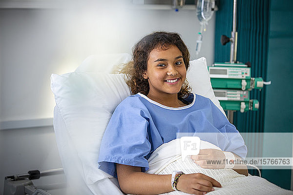 Portrait smiling girl patient in hospital bed