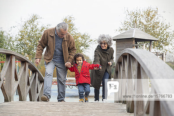 Großeltern gehen mit Enkel auf dem Steg spazieren