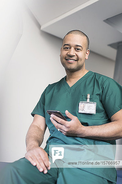 Porträt eines selbstbewussten männlichen Chirurgen mit Smartphone