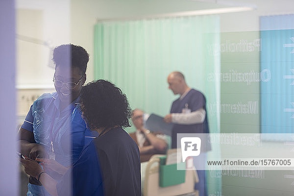 Ärztin und Krankenschwester unterhalten sich in einem Krankenhauszimmer