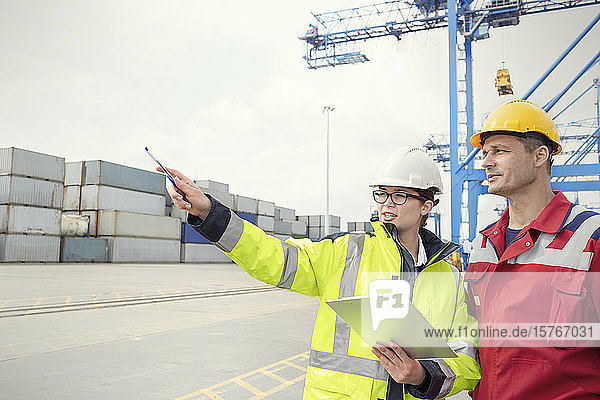Dockarbeiter mit Klemmbrett im Gespräch auf der Werft