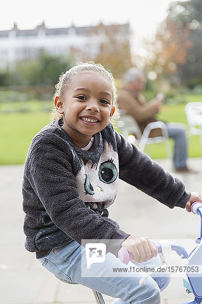 Porträt lächelndes Mädchen fährt Fahrrad auf dem Spielplatz