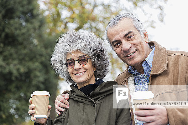 Porträt eines lächelnden  selbstbewussten älteren Paares beim Kaffeetrinken