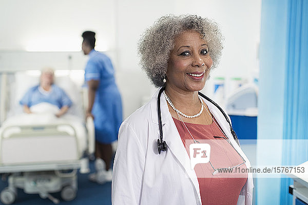 Portrait confident senior female doctor in hospital room