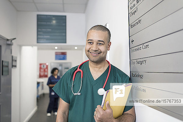 Porträt eines lächelnden  selbstbewussten männlichen Chirurgen im Krankenhausflur