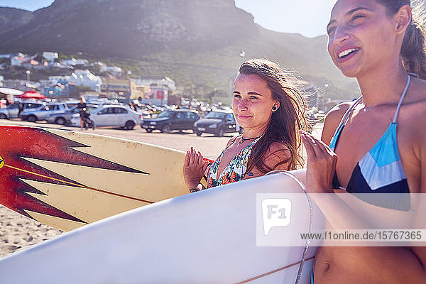 Junge Frauen mit Surfbrettern am sonnigen Sommerstrand