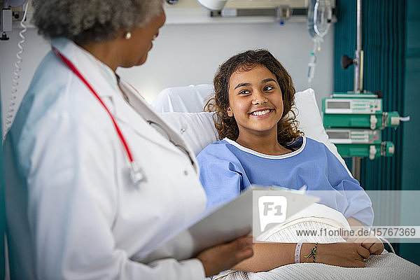 Lächelndes Mädchen Patientin im Gespräch mit Arzt im Krankenhaus Zimmer