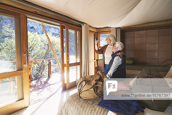 Älteres Paar benutzt Smartphone im Safari-Hotelzimmer