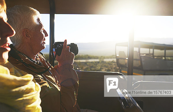 Älteres Paar mit Digitalkamera im Safari-Geländewagen