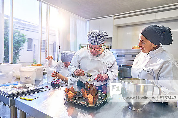 Koch hilft Schülerin mit Down-Syndrom beim Backen von Muffins in der Küche