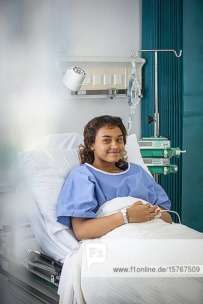 Portrait smiling girl patient in hospital bed