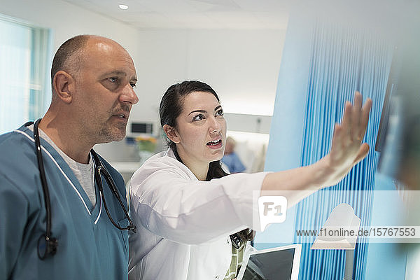 Ärzte besprechen Röntgenbilder im Krankenhauszimmer