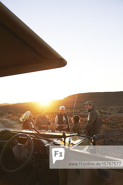 Safari-Reisegruppe trinkt Champagner bei Sonnenuntergang Südafrika