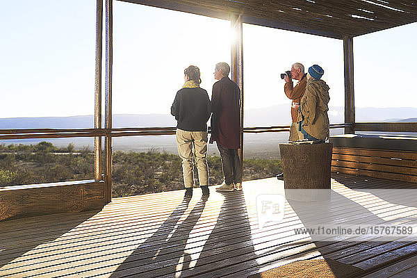 Freunde betrachten die Aussicht vom sonnigen Balkon der Safari-Lodge