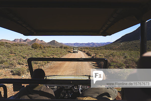 Safari tour guide drive off-road vehicle sunny dirt road South Africa