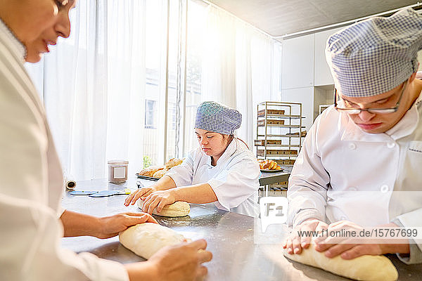 Schüler mit Down-Syndrom lernen in der Küche Brot zu backen
