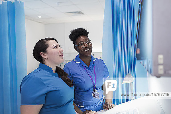Ärztin und Krankenschwester untersuchen Röntgenbilder in einem Krankenhauszimmer