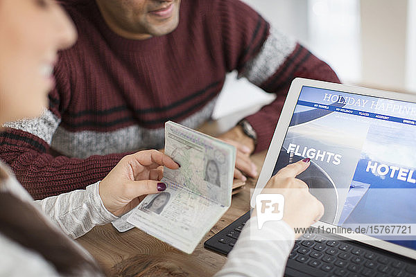 Ehepaar mit Reisepass plant Urlaub auf digitalem Tablet