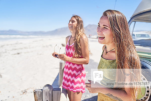 Glückliche junge Frauen Freunde lachen am sonnigen Strand