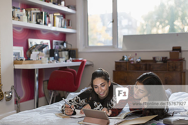 Teenager-Mädchen Freunde studieren tun Hausaufgaben auf dem Bett