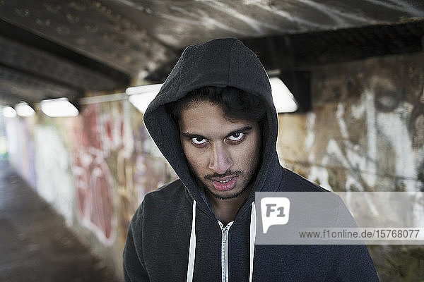 Porträt eines bedrohlichen jungen Mannes in einem städtischen Tunnel
