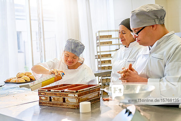 Koch und Schüler mit Down-Syndrom backen Brot in der Küche
