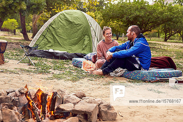 Junges Paar beim Zelten  das sich auf dem Campingplatz unterhält