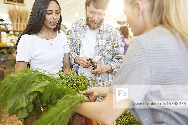 Ehepaar kauft Gemüse auf dem Bauernmarkt