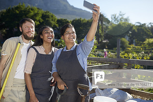 Arbeiter posieren für ein Selfie in einer sonnigen Gärtnerei