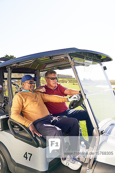Ältere männliche Golfer fahren im Golfwagen