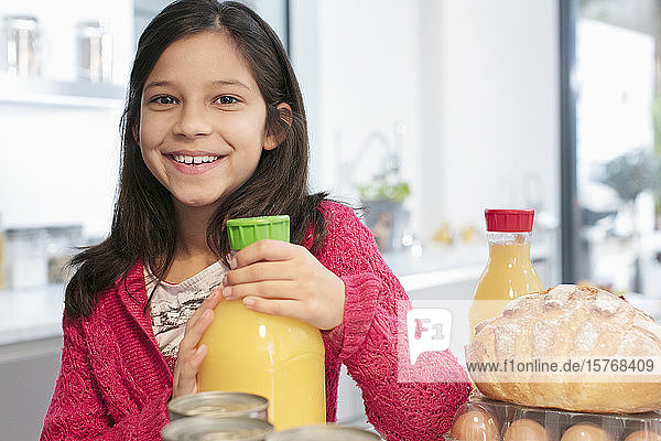 Portrait lächelndes Mädchen mit Orangensaft in der Küche