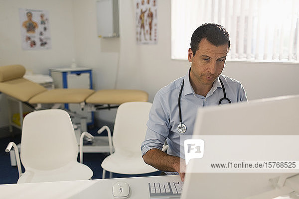 Männlicher Arzt arbeitet am Computer in einer Arztpraxis