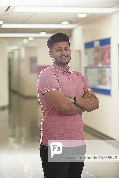 Porträt selbstbewusster junger männlicher Student im Korridor