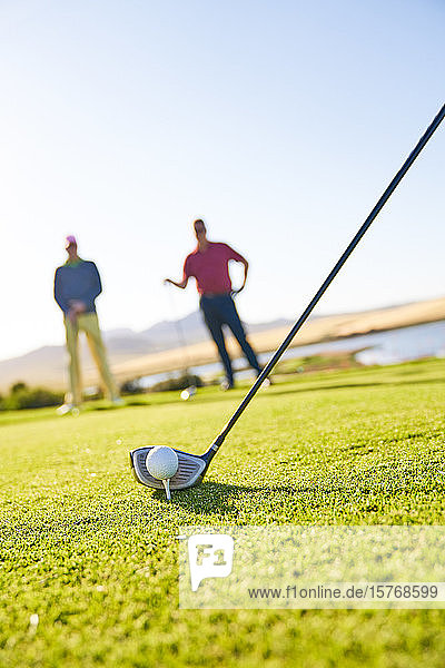 Ein Golfer bereitet sich auf den Abschlag auf einem sonnigen Golfplatz vor