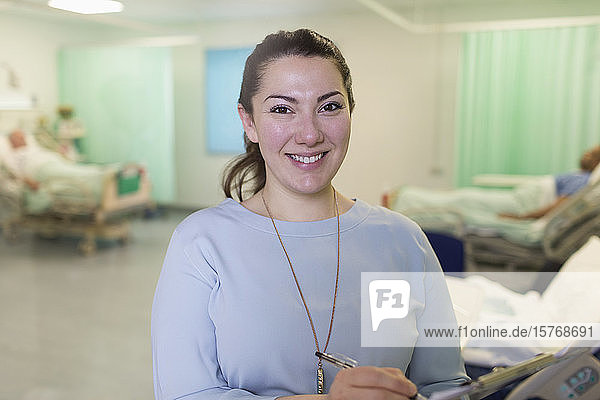 Porträt einer selbstbewussten Ärztin bei der Visite in einer Krankenstation