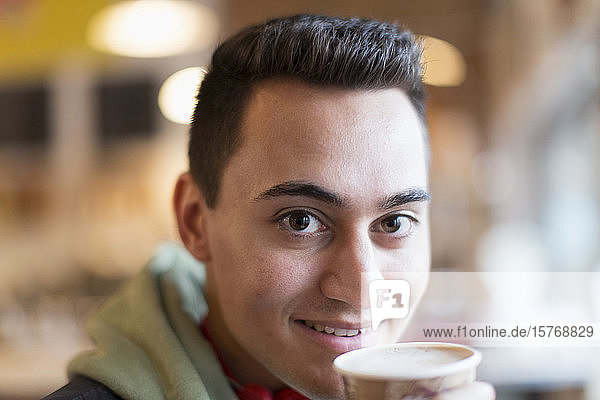 Nahaufnahme Porträt selbstbewusster junger Mann beim Kaffeetrinken