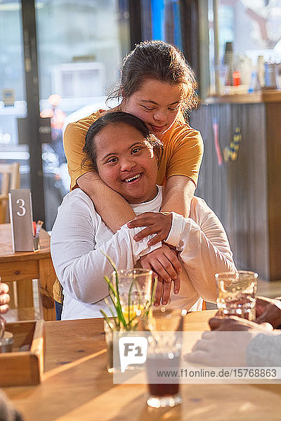 Porträt glückliche  liebevolle junge Frauen mit Down-Syndrom in einem Café