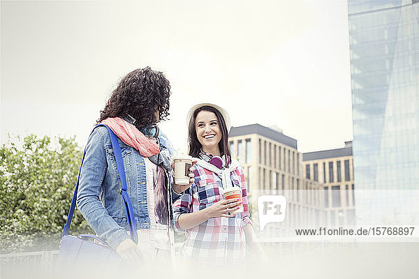 Junge Frauen Freunde mit Kaffee zu Fuß in der Stadt